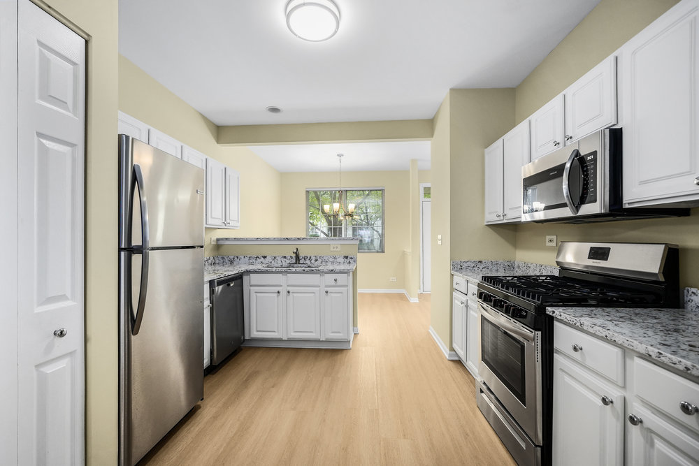 2277 Reflections Drive, Unit 2277 Aurora, IL 60502 - Photo 5 of 15 a kitchen with stainless steel appliances granite countertop a refrigerator stove and sink