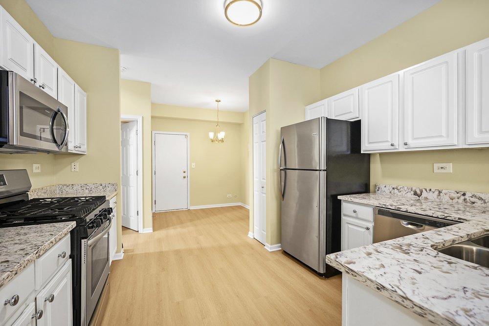 2277 Reflections Drive, Unit 2277 Aurora, IL 60502 - Photo 6 of 15 a kitchen with a refrigerator and a stove top oven