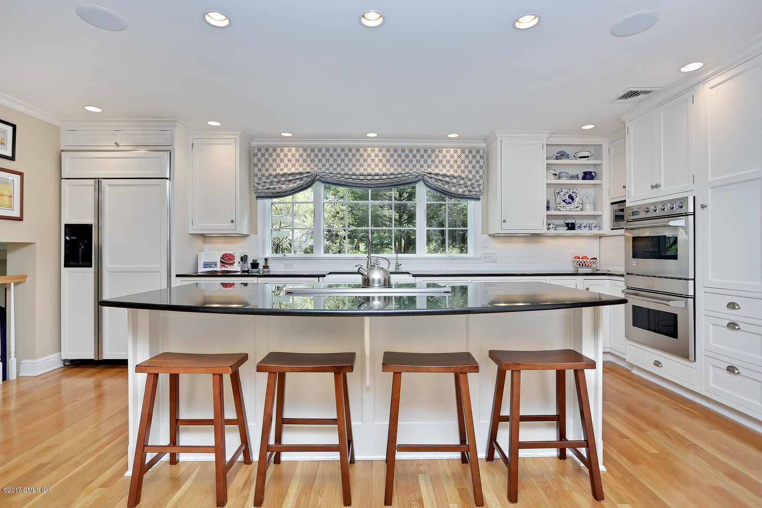 87 Hunting Ridge Road Stamford, CT 06903 - Photo 4 of 31 a kitchen with stainless steel appliances granite countertop a table chairs stove microwave and cabinets
