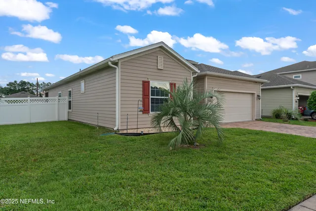 an aerial view of residential houses with outdoor space and parking