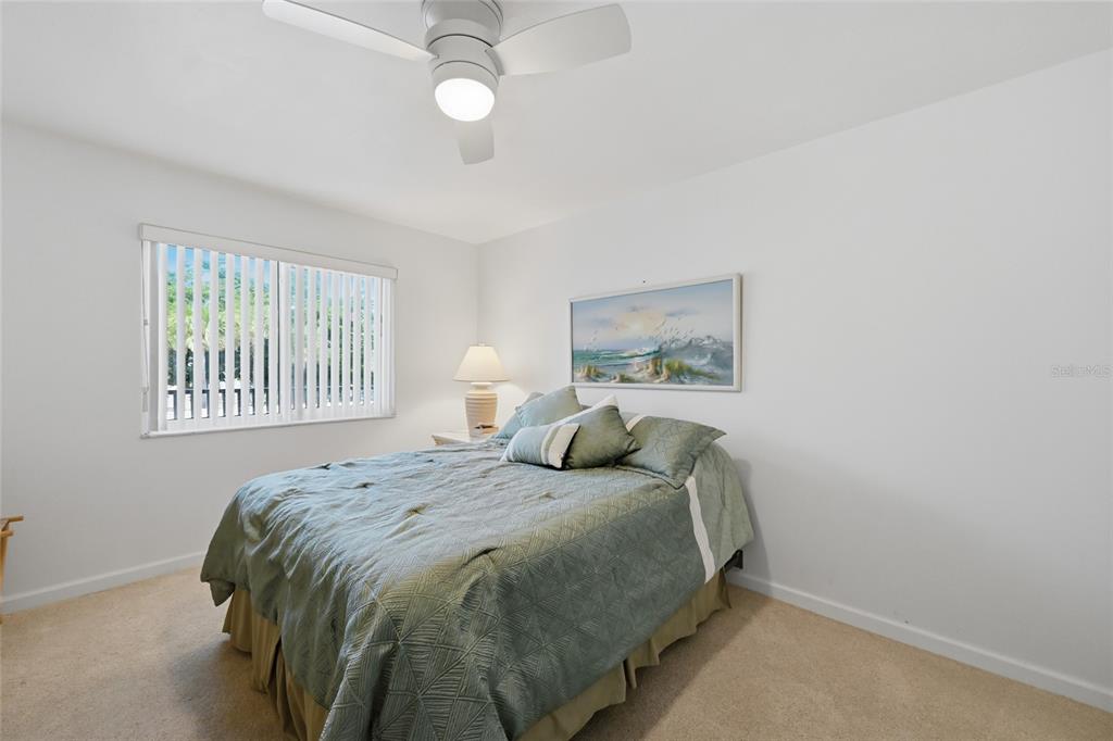 8977 Midnight Pass Road, Unit 223 Sarasota, FL 34242 - Photo 28 of 82 a bedroom with a bed and a painting on the wall