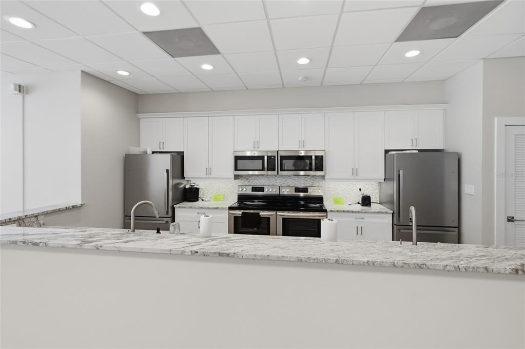 8977 Midnight Pass Road, Unit 223 Sarasota, FL 34242 - Photo 60 of 82 a kitchen with stainless steel appliances granite countertop a sink refrigerator and microwave