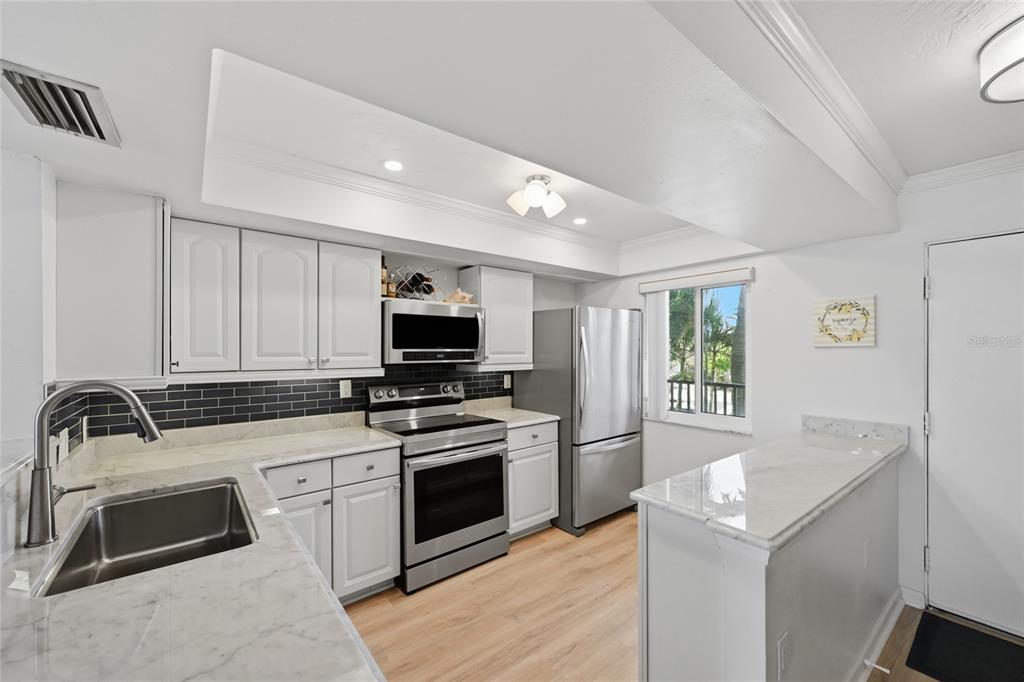 8977 Midnight Pass Road, Unit 223 Sarasota, FL 34242 - Photo 6 of 82 a kitchen with a sink stove and microwave