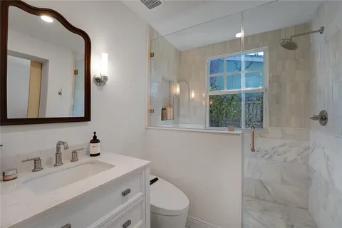 a bathroom with a sink toilet vanity and shower