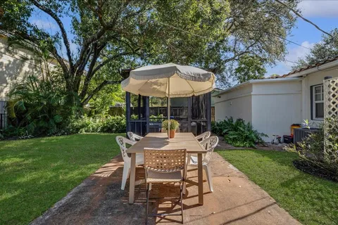 a view of a wooden table and chairs under an umbrella