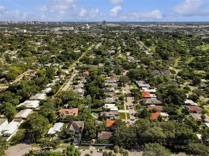 an aerial view of residential houses with outdoor space and trees