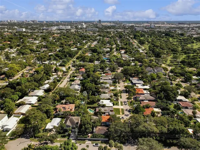 an aerial view of residential houses with outdoor space and trees
