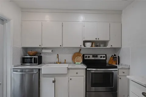 a kitchen with stainless steel appliances granite countertop a stove a refrigerator and a white cabinets