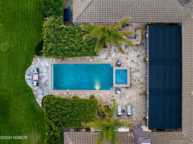 a view of a patio with chairs and table in a backyard