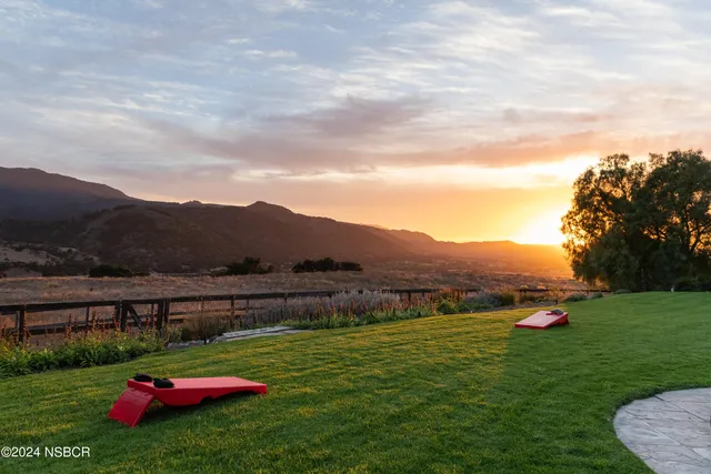 a view of swimming pool with seating area and trees in the background