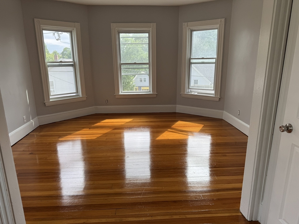 72 Forest Street, Unit 2 Attleboro, MA 02703 - Photo 3 of 10 a view of an empty room with window and wooden floor