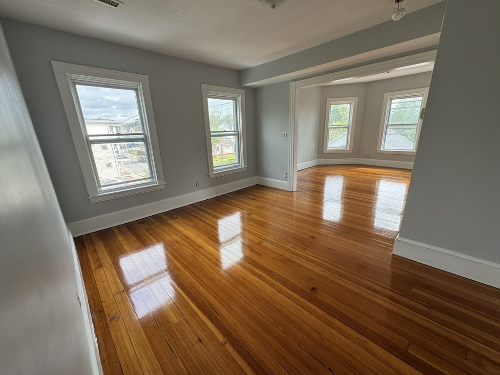 72 Forest Street, Unit 2 Attleboro, MA 02703 - Photo 4 of 10 a view of empty room with window and wooden floor
