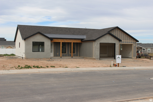 4933 East Remington Road Cedar City, UT 84721 - Photo 31 of 33 Modern residence featuring a dark shingle roof, light-toned stucco, and a covered entry with exposed wood beams