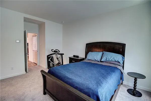 a bedroom with a bed and a lamp on dresser