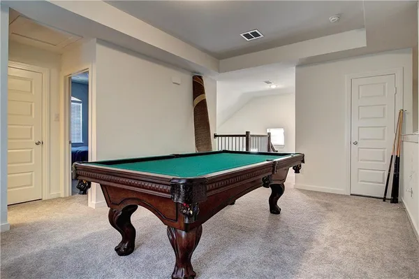 a room with pool table and windows