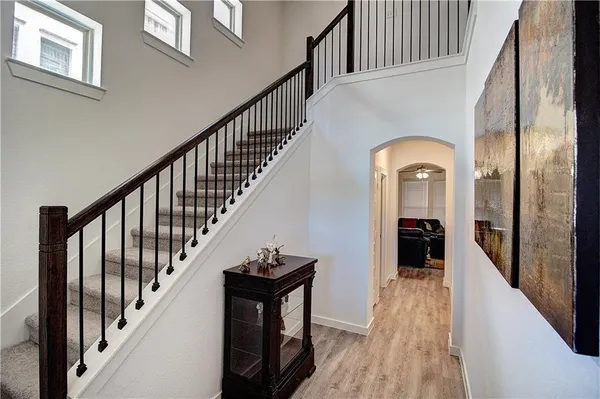 a view of staircase with lots of frames on wall and a window