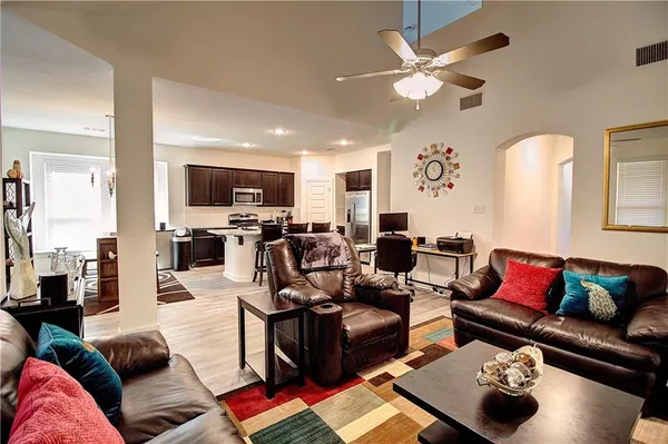 a living room with furniture ceiling fan and a rug