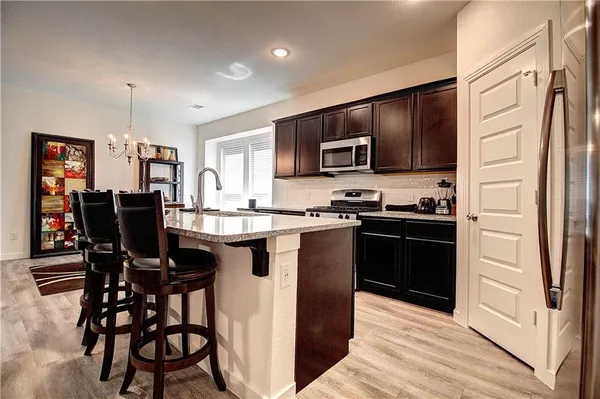 a kitchen with stainless steel appliances granite countertop a refrigerator and a stove top oven