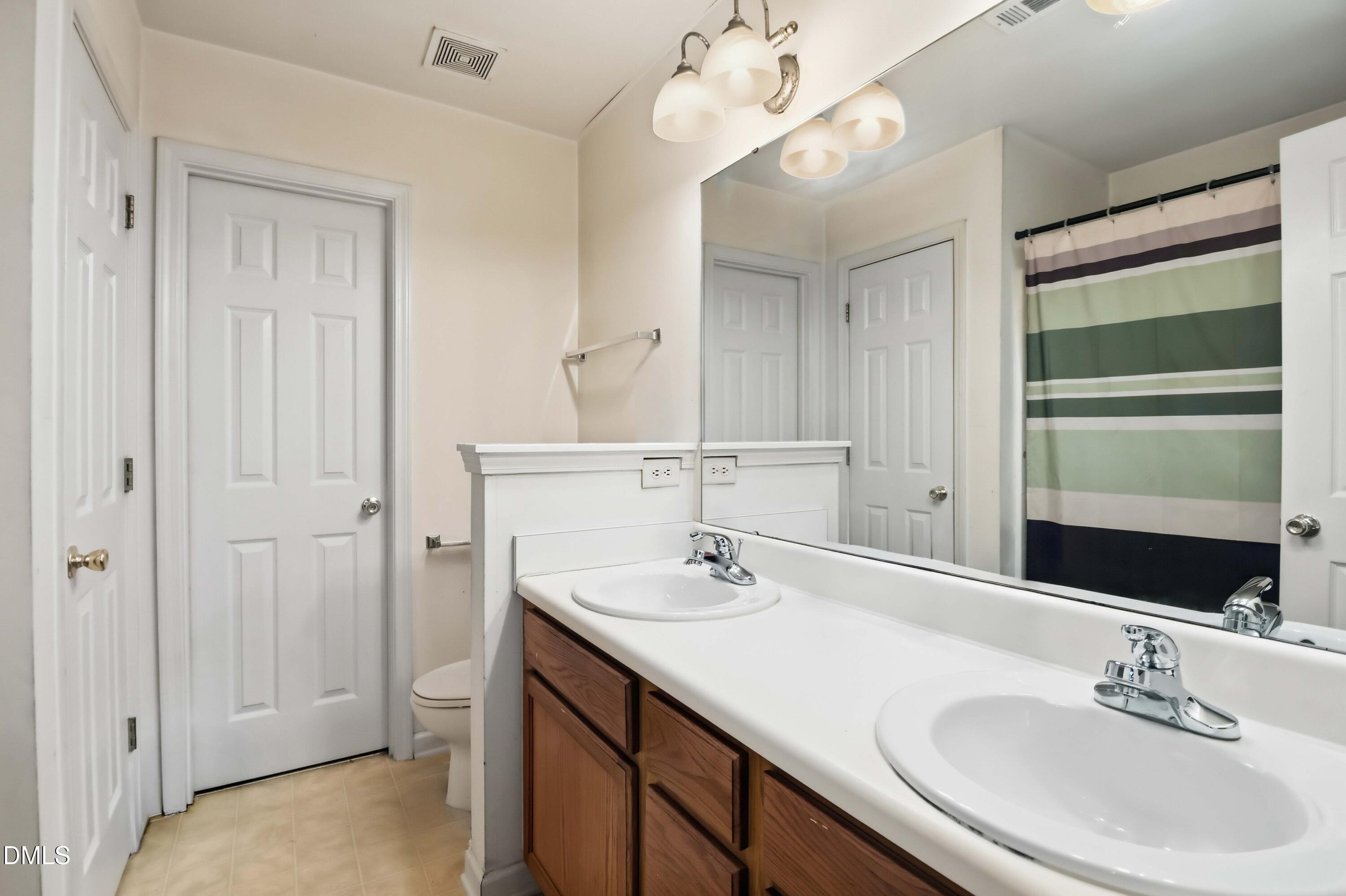 1504 Springshire Court Raleigh, NC 27610 - Photo 8 of 16 a bathroom with a sink a toilet and a mirror