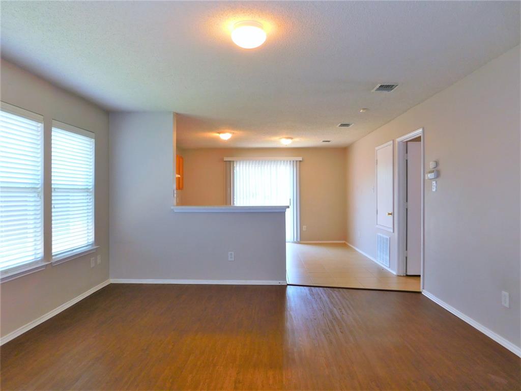 2408 Rolling Ridge Drive Little Elm, TX 75068 - Photo 7 of 25 an empty room with wooden floor and windows