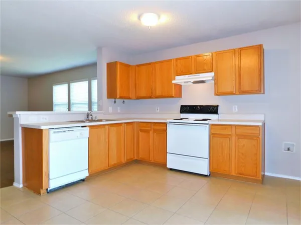 a kitchen with granite countertop a sink cabinets stainless steel appliances and a window