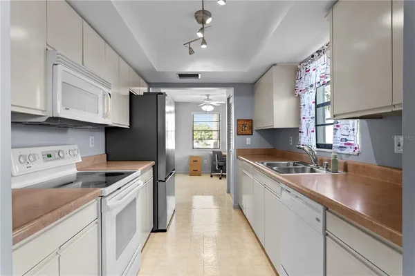 a kitchen with kitchen island granite countertop a sink stainless steel appliances cabinets and a counter top space