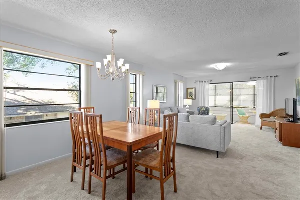a dining room with furniture a chandelier and window