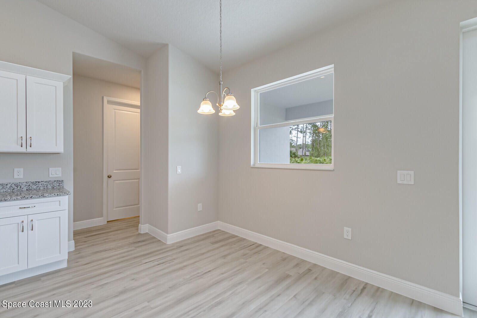 931 Thompson Road Southwest Palm Bay, FL 32908 - Photo 11 of 24 a view of an empty room with wooden floor and a window