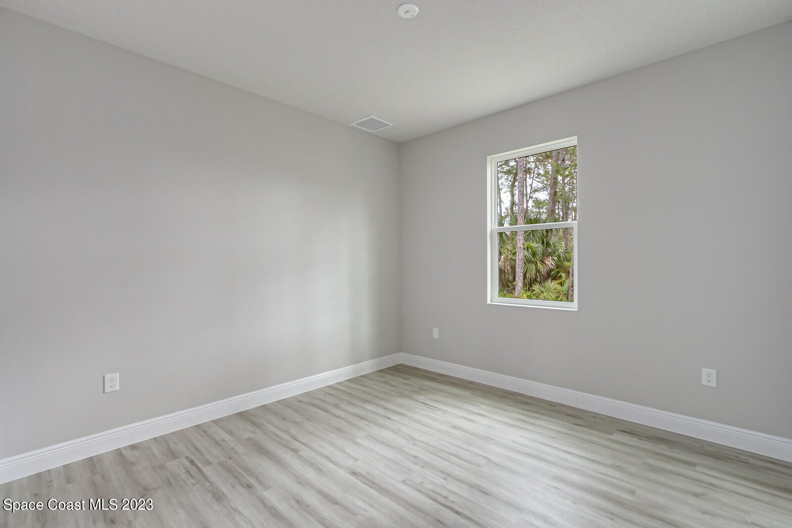 931 Thompson Road Southwest Palm Bay, FL 32908 - Photo 13 of 24 wooden floor in an empty room with a window