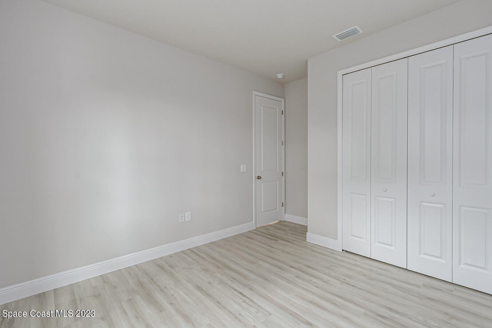 931 Thompson Road Southwest Palm Bay, FL 32908 - Photo 14 of 24 a view of an empty room with wooden floor