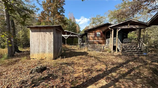 a view of house with backyard and trees