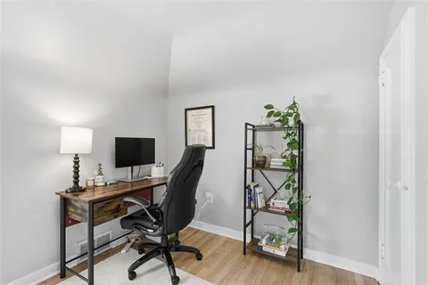 a view of a workspace with furniture and a window