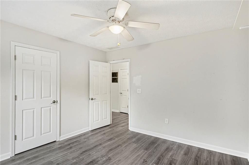 1752 Highway 162 Covington, GA 30016 - Photo 26 of 29 an empty room with wooden floor and ceiling fan