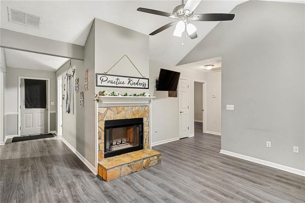1752 Highway 162 Covington, GA 30016 - Photo 8 of 29 a view of a livingroom with wooden floor a ceiling fan a fireplace and windows