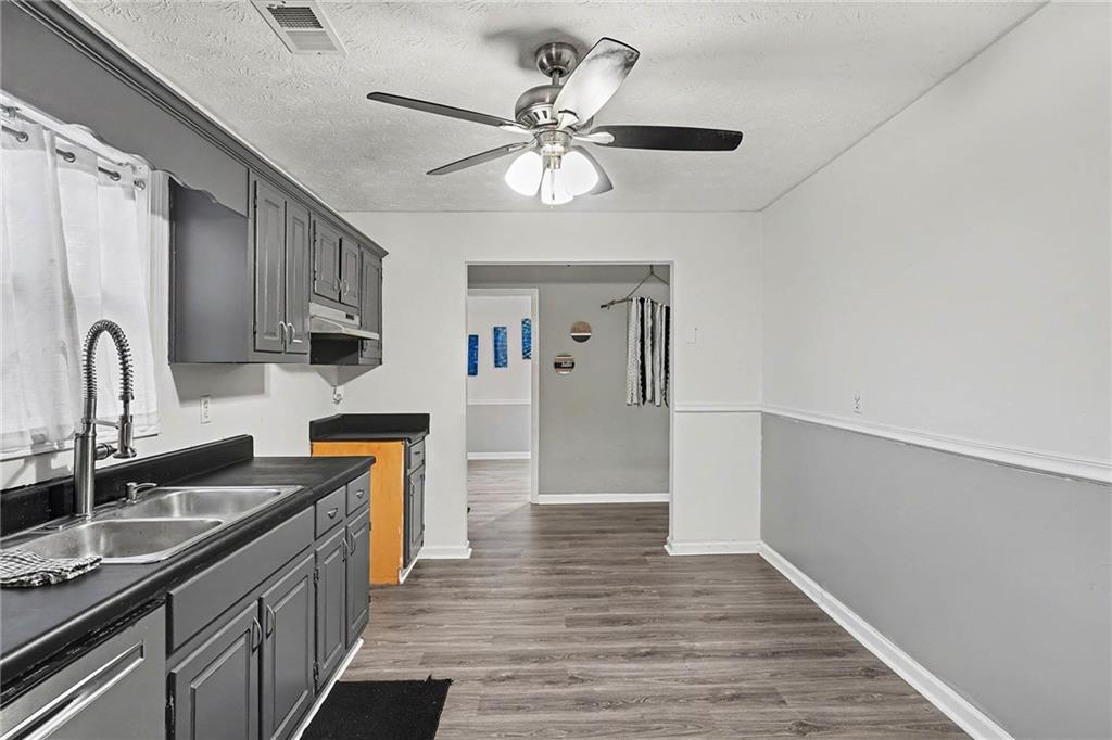 1752 Highway 162 Covington, GA 30016 - Photo 10 of 29 a kitchen with stainless steel appliances a sink cabinets and wooden floor