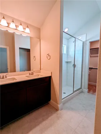 a bathroom with a double vanity sink mirror and shower