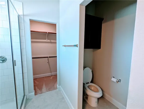 a bathroom with a granite countertop toilet and a sink