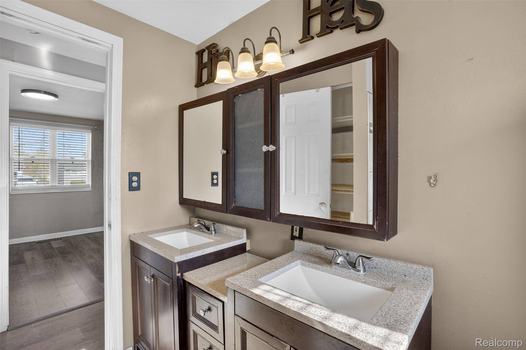 6169 Neff Road Mount Morris, MI 48458 - Photo 15 of 49 Full bathroom with two vanities and wood finished floors