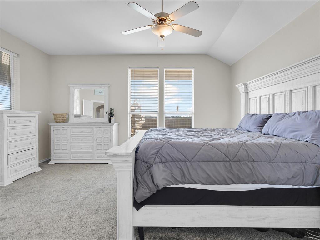 205 King George Road Ponder, TX 76259 - Photo 17 of 32 a bedroom with a bed and a chandelier