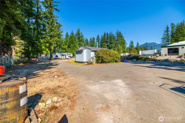 a view of backyard with outdoor seating and trees in the background