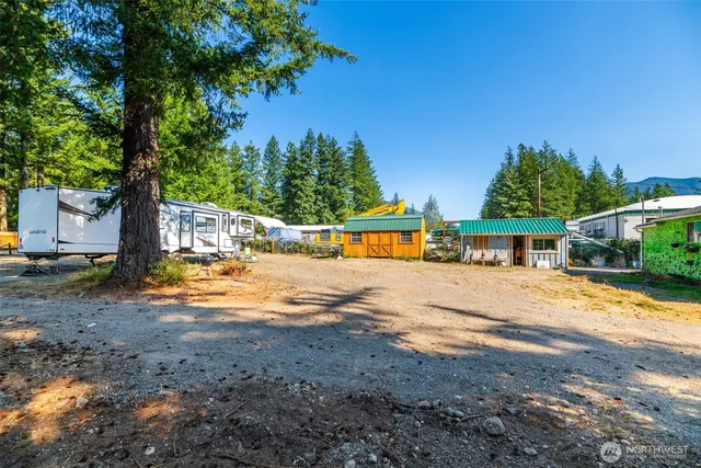 a backyard of a house with table and chairs a barbeque with wooden fence