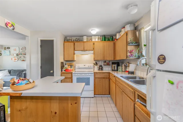 a kitchen with stainless steel appliances granite countertop a stove a sink dishwasher and cabinets with wooden floor