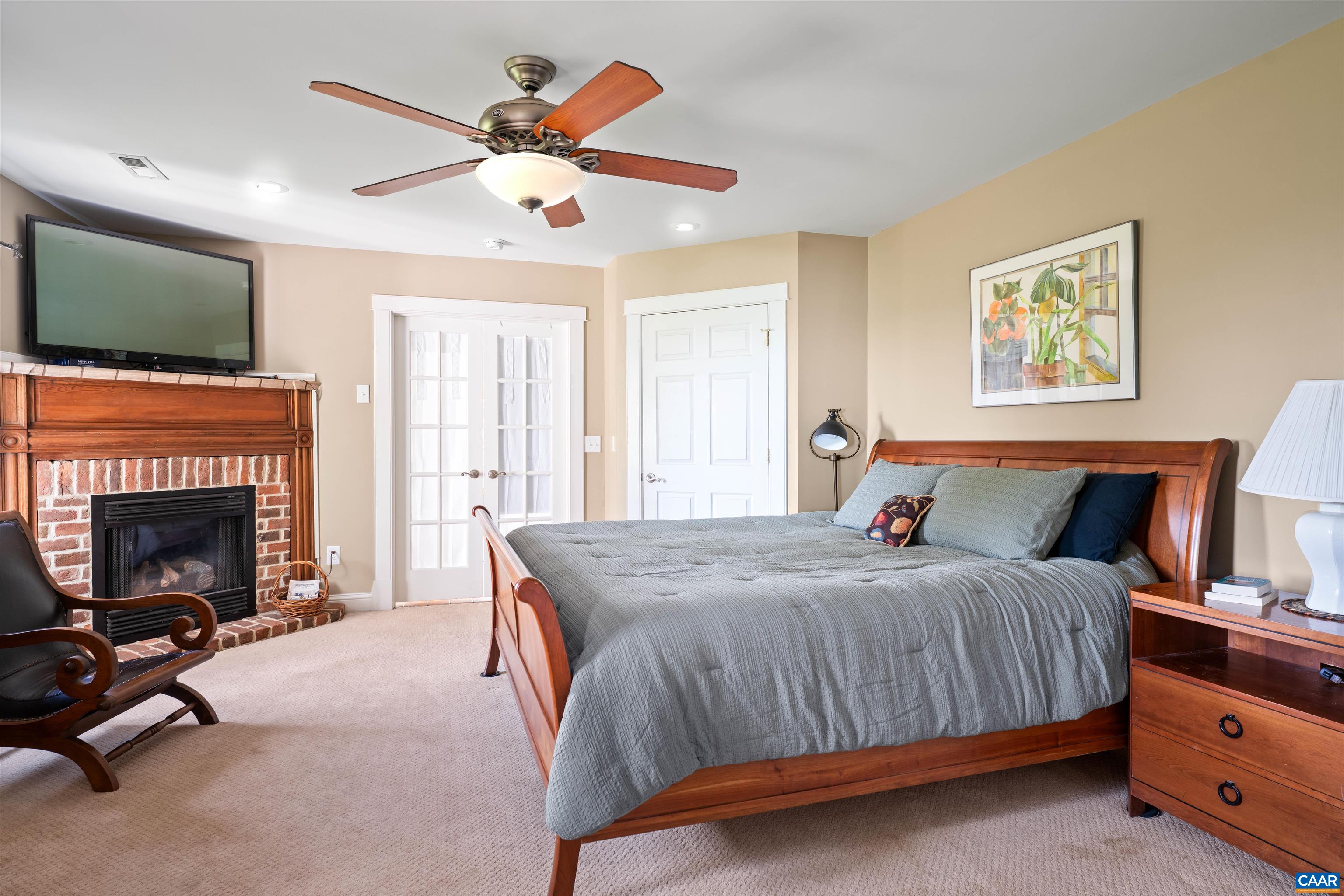 3486 Fredericksburg Road Ruckersville, VA 22968 - Photo 10 of 37 a bedroom with a bed a flat screen tv and a fireplace