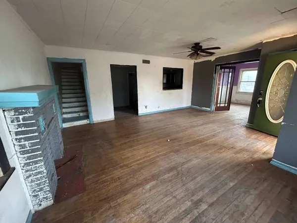 a view of a livingroom with wooden floor and a ceiling fan