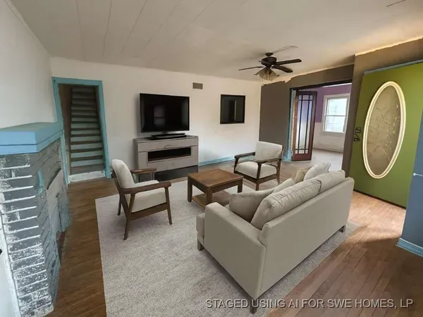 a living room with furniture a flat screen tv and a fireplace