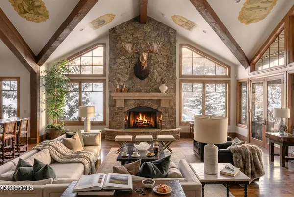 a living room with furniture fireplace and large windows