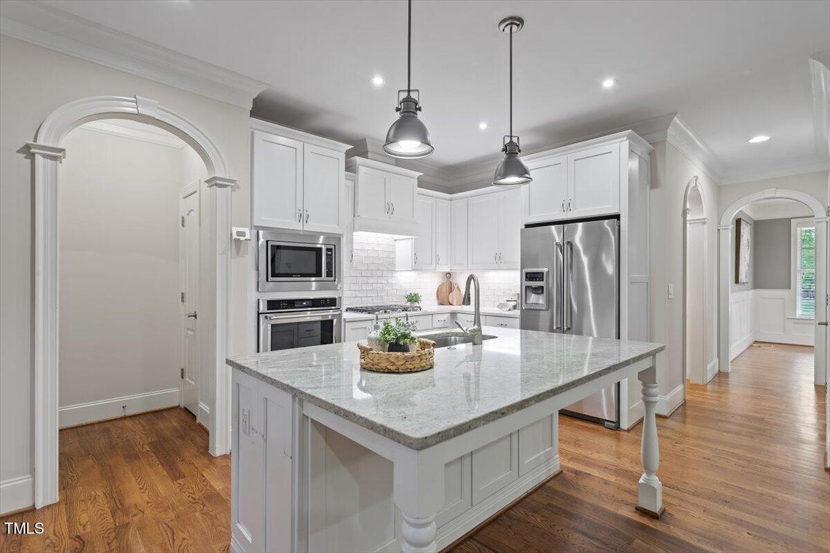 715 Kimbrough Street Raleigh, NC 27608 - Photo 12 of 42 a kitchen with stainless steel appliances granite countertop a refrigerator a stove and a wooden floors