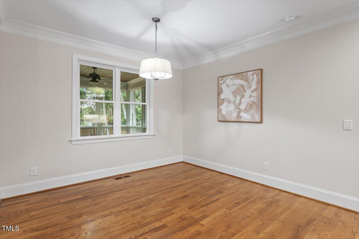 715 Kimbrough Street Raleigh, NC 27608 - Photo 15 of 42 a view of an empty room with wooden floor chandelier and windows
