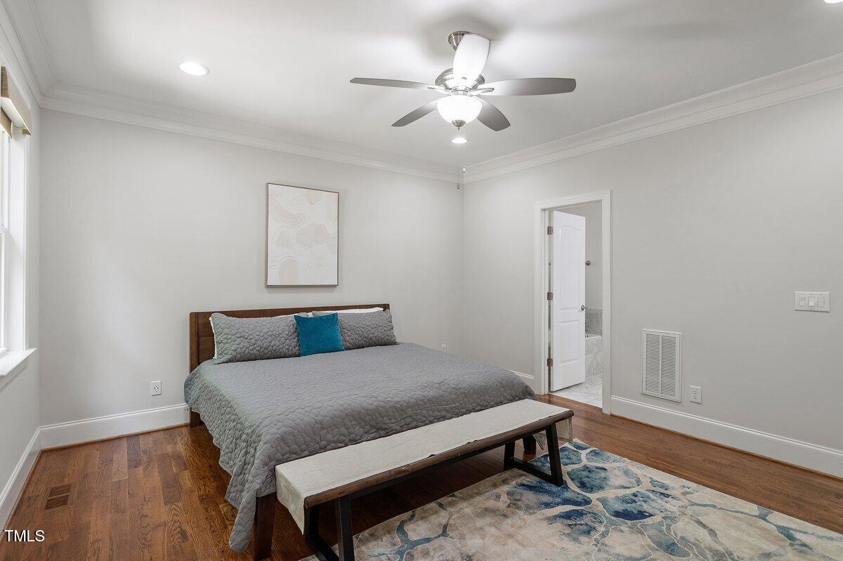 715 Kimbrough Street Raleigh, NC 27608 - Photo 19 of 42 a bedroom with a bed and a chandelier