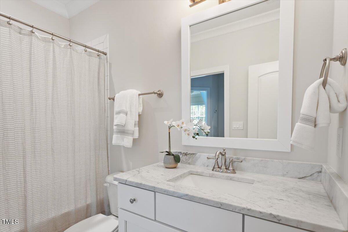 715 Kimbrough Street Raleigh, NC 27608 - Photo 30 of 42 a bathroom with a granite countertop sink and a mirror